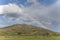 Rainbow on barren slopes near Omarama, New Zealand