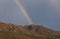 Rainbow behind mountain range, copy space