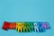 Rainbow bright colorful clothes pins on blue background, copy sp