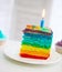 Rainbow cake decorated with birthday candle