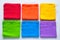 Rainbow cloth patterns on white background, red, orange, yellow, green, blue and purple rags top view