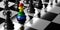 Rainbow color Chess pawn among black pawns on chessboard, Inclusion diversity and stand out