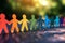 Rainbow colored paper human figures holding their hands on nature background. Diversity and Inclusion concept