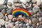 Rainbow colored stone and word Love on the beach