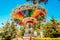 A rainbow colored swing carousel at an amusement park.