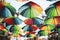Rainbow colored umbrellas hang in a public park