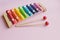 Rainbow Colored Wooden Toy Xylophone on pink bacground. toy glockenspiel made of metal and wood