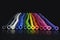 Rainbow of colorful uninflated balloons lined up on black background