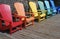 Rainbow of coloured chairs on the dock in summer