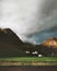 Rainbow and dark clouds over village in mountains