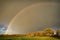 Rainbow and dramatic gray sky with clouds landscape