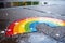 Rainbow Drawn on Wet City Asphalt