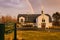 A rainbow emerges over church after a very warm day and afternoon rain