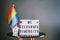 Rainbow flag with text CELEBRATE DIVERSITY message on the lightbox standing on the wooden table on the dark grey wall