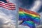 Rainbow flags on display against a cloudy sky