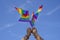 Rainbow flags LGBT community symbol are being waved by a man hands on background clear blue sky