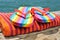 Rainbow flip-flops and towel on a dock