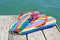 Rainbow flip-flops on a weathered dock