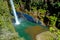 A rainbow at the foot of a waterfall.