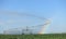 A rainbow forms in the mist of an agricultural sprinkler