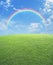 Rainbow with green grass field over blue sky