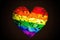 Rainbow heart on black background, LGBTQ symbol. Generative AI