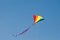 Rainbow kite design flying on blue sky.