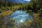 Rainbow lake, geyser lake. Colored spots under water. Mysterious mystical lake in forest, Altai, Siberia, Russia.