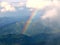 Rainbow between the land and clouds high in Carpathian Mountains