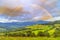 Rainbow landscape and dramatic rain sky over the art rural landscape