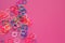 Rainbow loom bands bracelets on pink background. Colorful ties for waving hair. Children hobby - handmade bracelets