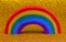 rainbow with the many colors on the golden glitter background