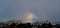 Rainbow mist pattern over industrial landscape.