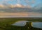 Rainbow in the nice sunset scene over a lake with forest sky