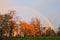 Rainbow over autumn color tree and buildings