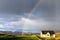 A rainbow over a cute cottage on a farm
