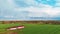 The rainbow over the green field after storm with rain, during spring, aerial view under heavy clouds before thunderstorm