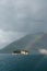 Rainbow over the island of St. George on the background of green mountains