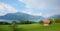 Rainbow over lake Thunersee, green pasture with hut, mountain landscape Berner Oberland, Switzerland