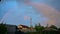 Rainbow over over trees and houses Panoramic view Cloudy landscape
