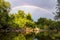 Rainbow over river in forest. Idyllic landscape