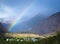 Rainbow over the village in the mountains. Landscape. Toned