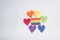 Rainbow paper hearts surrounding rainbow strips of paper. LGBT concept - image