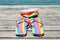Rainbow-patterned flip-flops and swimsuit on dock