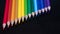 Rainbow pencil colors on a black glass