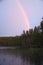 Rainbow reflected in the lake when it rains. in the background forest