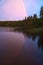 Rainbow reflected in the lake when it rains. on the lake reeds and water lilies