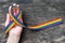 Rainbow ribbon awareness on human hand on grunge aged background, clipping path: Symbolic color logo icon
