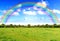 Rainbow sky clouds and grass on meadow