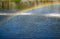 Rainbow spray fountain on the background of the river